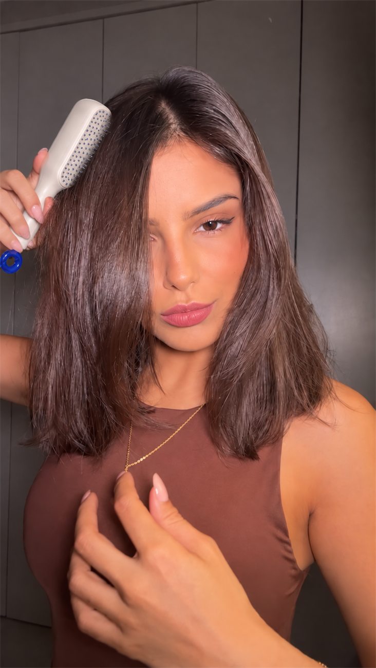 Mulher penteando o cabelo com a Escova Mágica Retrátil Premium